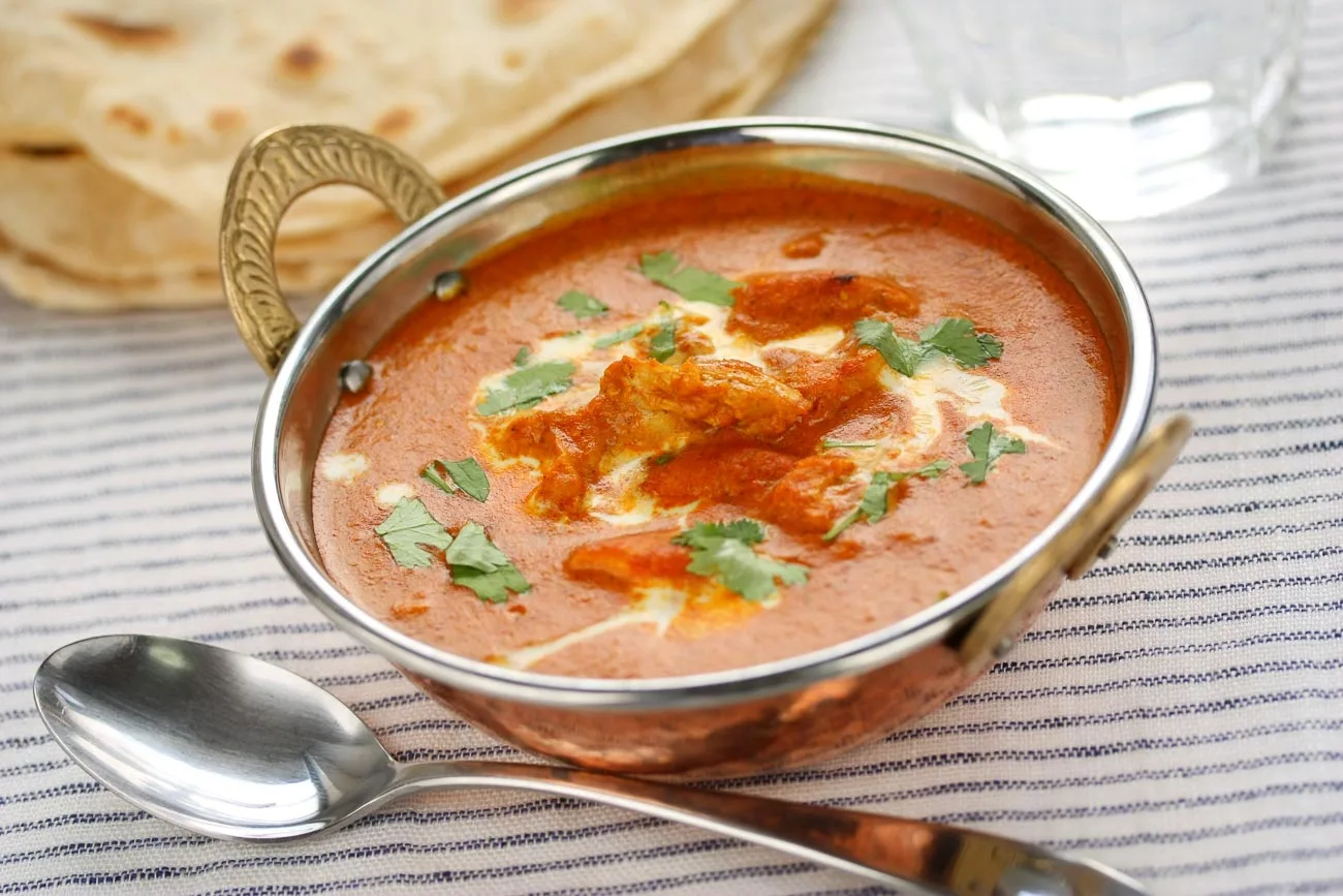 Tender butter chicken pieces in a buttery tomato sauce