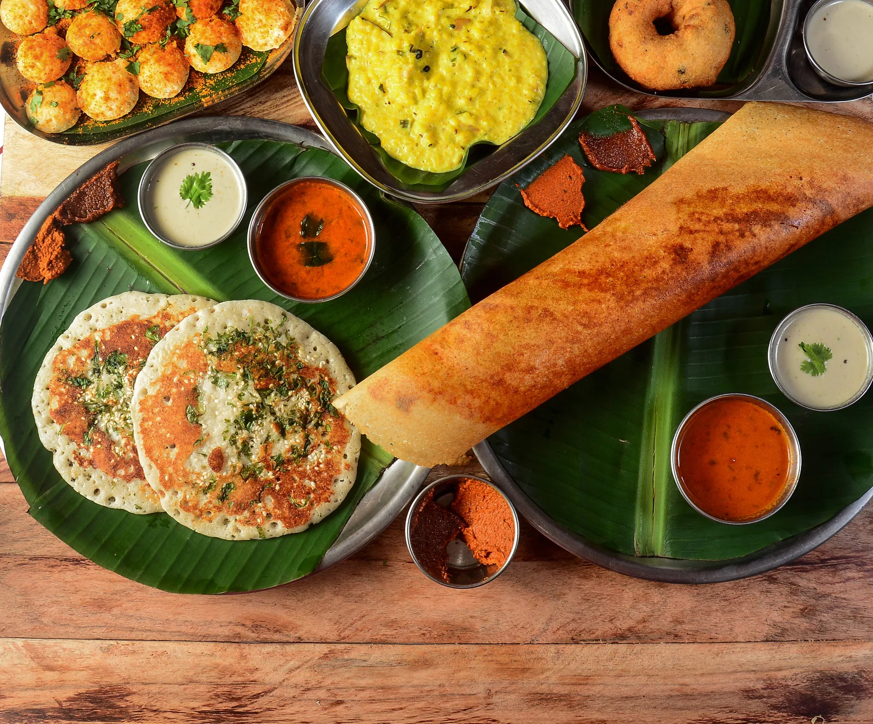 A display of South Indian dishes including dosa and chutneys