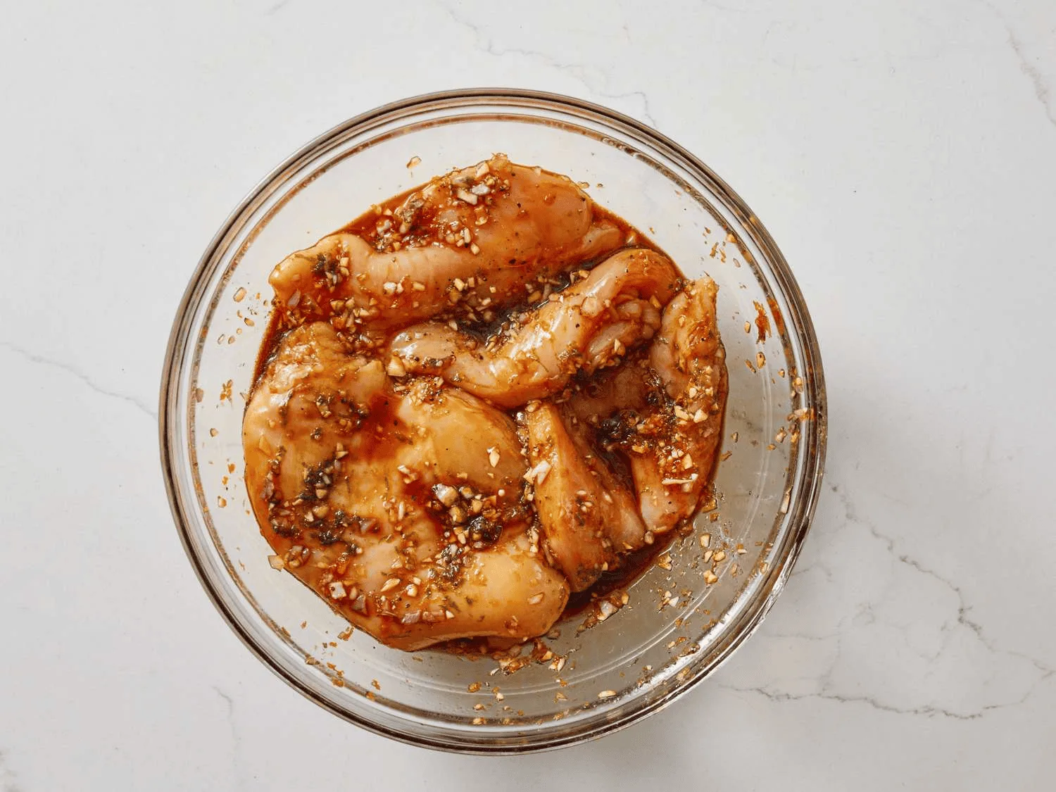 Chicken pieces marinating in yoghurt and Indian spices in a bowl
