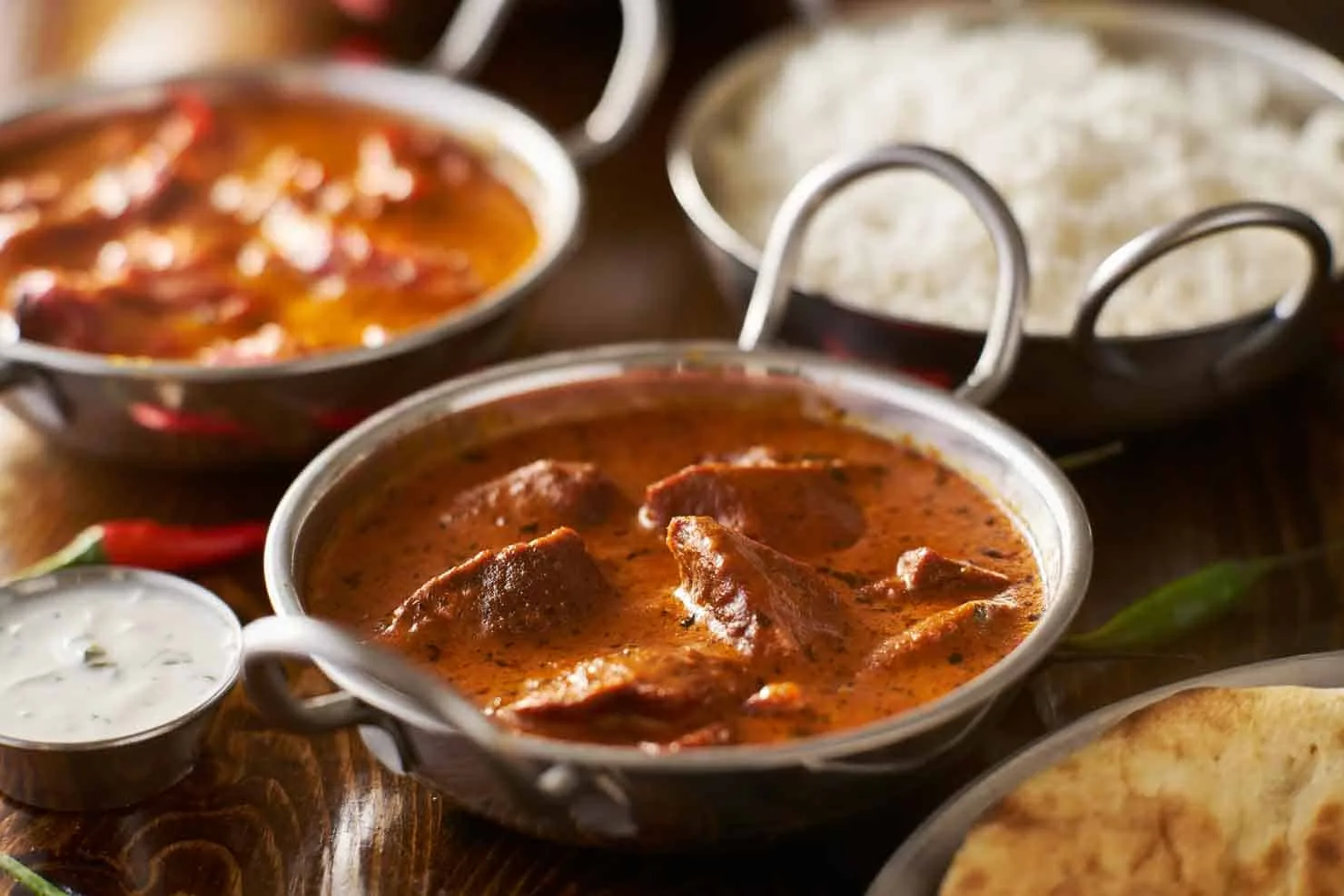 Lamb tikka masala served in a balti dish with rice and naan