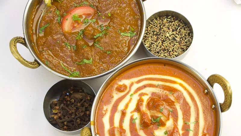 Guests helping themselves to Indian dishes from a buffet at a catered function