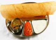 Masala dosa filled with spiced potato, with chutneys and sambar